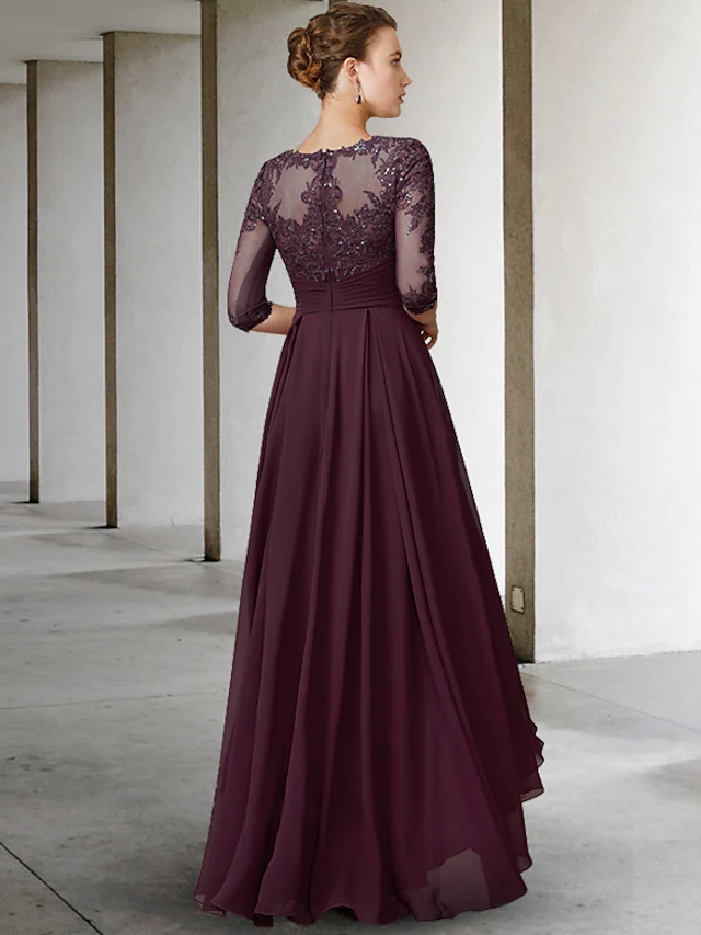 Back view of an A-line mother of the bride dress featuring asymmetrical pleats and lace appliques.