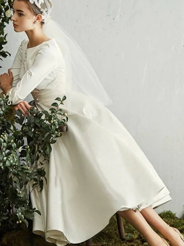Elegant A-Line wedding dress with jewel neck and half sleeves.