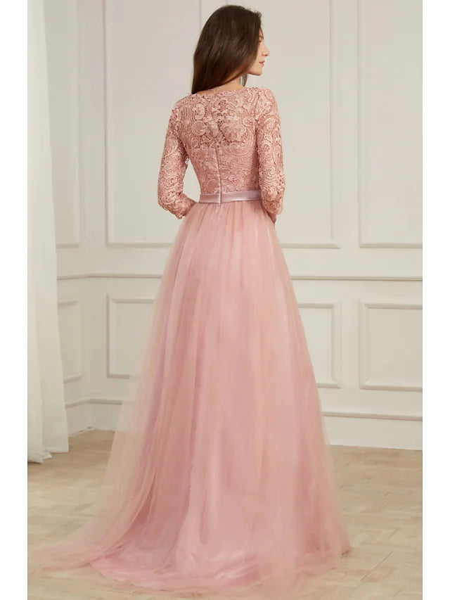 Woman posing in a formal A-line lace dress with appliques.