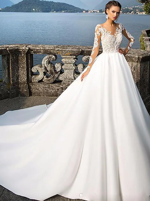 Front view of an A-Line satin wedding dress with jewel neck and long sleeves.