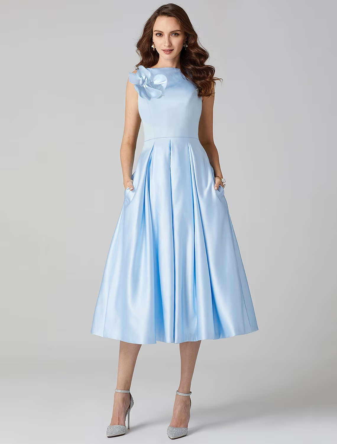Elegant A-line satin tea length cocktail dress with jewel neck and pleats.