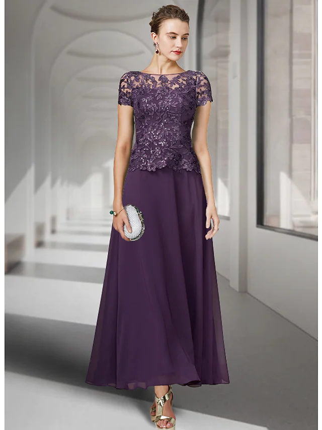 Woman wearing an elegant A-Line Mother of the Bride dress with jewel neck and short sleeves.