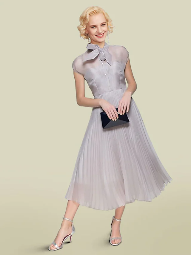 Elegant A-line mother of the bride dress with jewel neck, short sleeves, bows, and pleats.