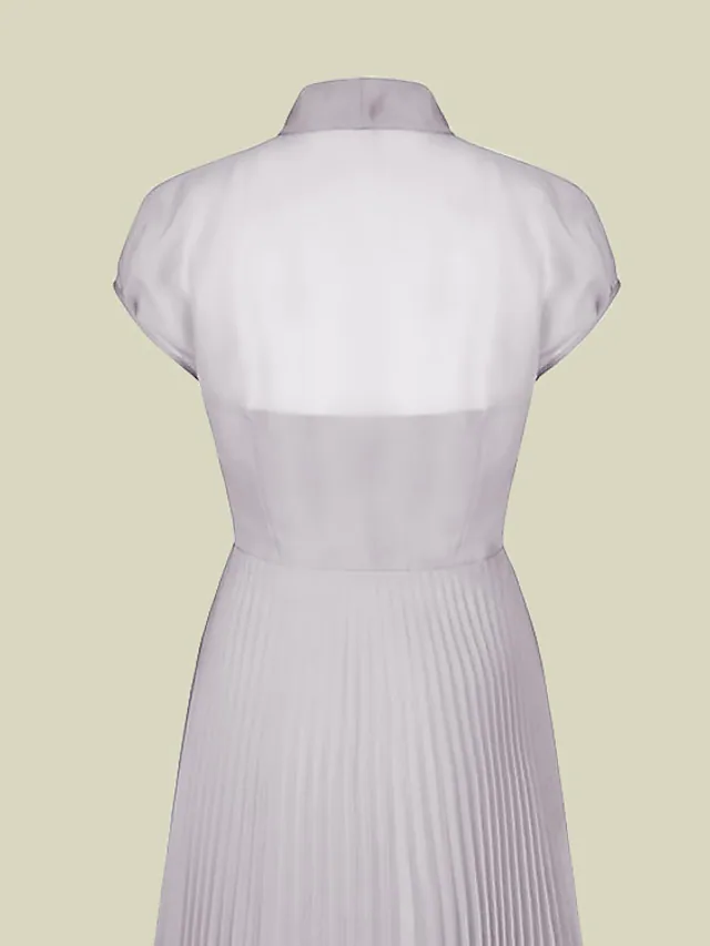 Close-up of the jewel neck, short sleeve, and bow detail on the dress.