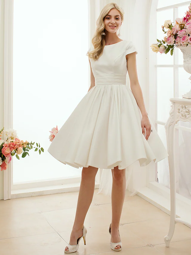 Elegant A-line white wedding dress with jewel neck and short sleeves.
