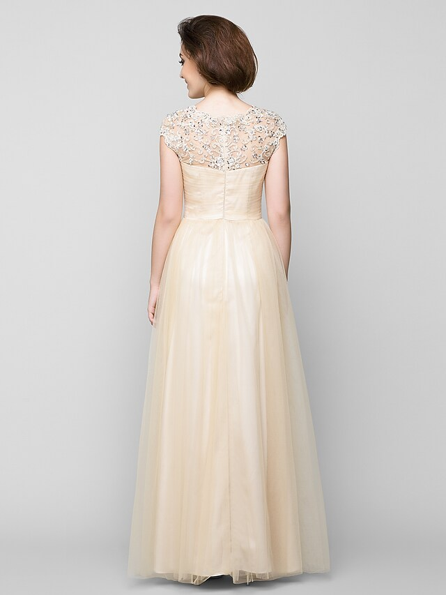 Side view of the floor-length A-Line tulle gown with criss-cross beading.