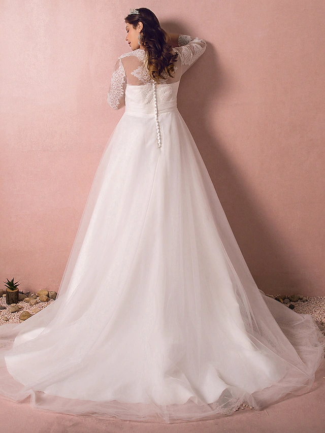 Side profile of bride in A-line lace wedding dress with illusion sleeves.