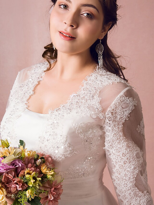 Detail of the long illusion lace sleeve with delicate floral patterns.