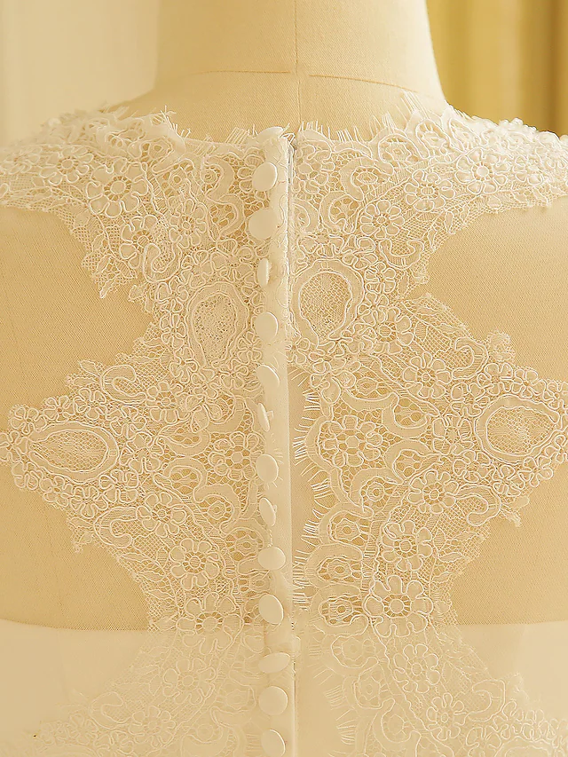 Rear view of the wedding dress highlighting the lace insert and train.