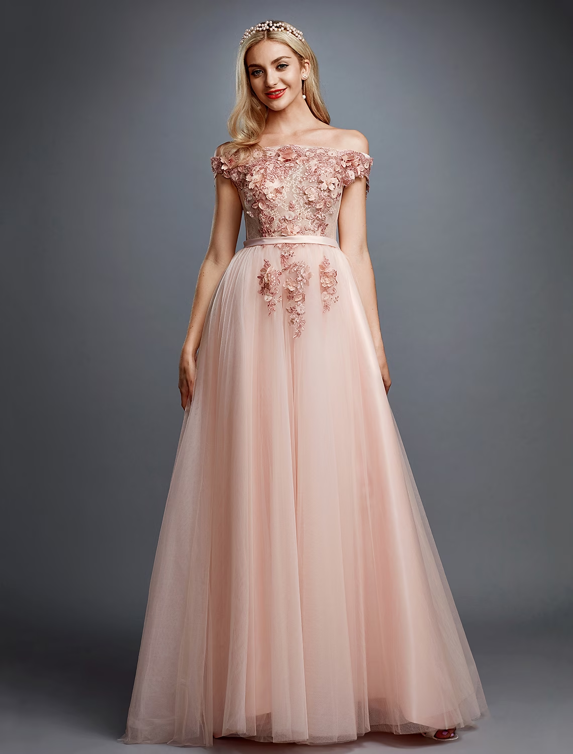 Close-up of the floral appliques and lace detail on the off-shoulder dress.