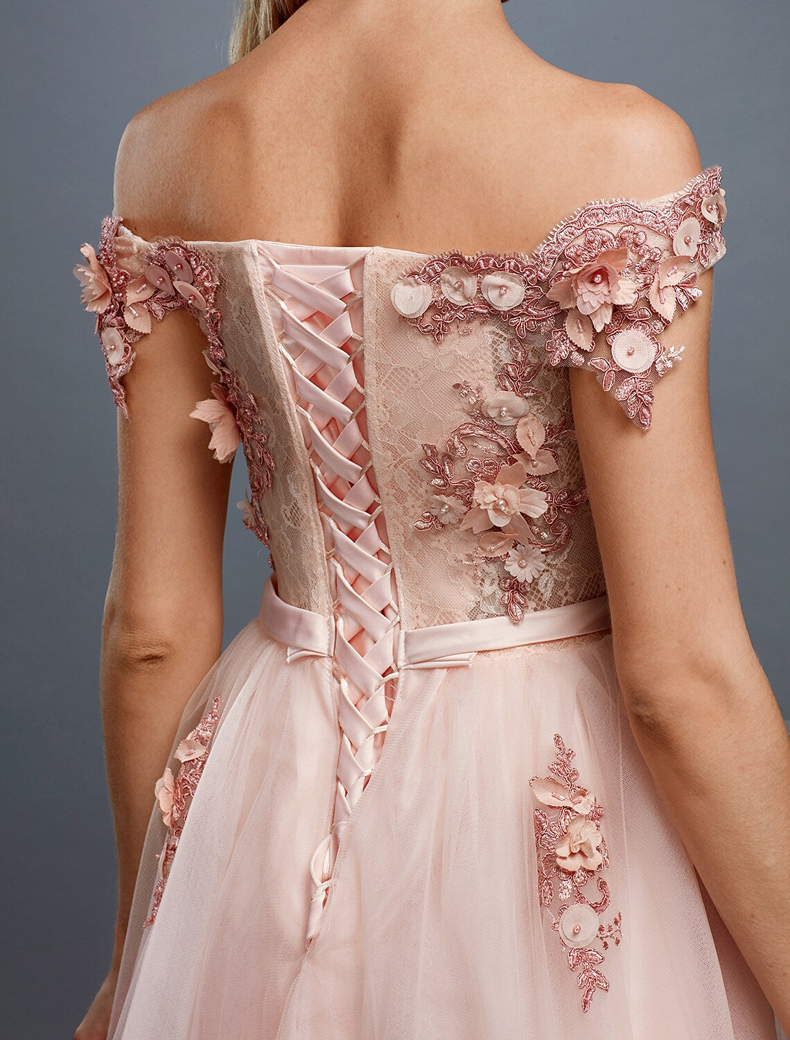 Detailed view of the off-shoulder neckline and floral embellishments.