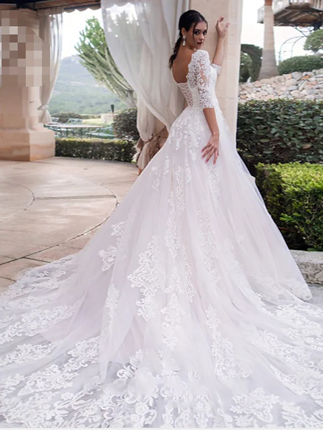 Back view of an A-line off-shoulder wedding dress with illusion lace sleeves.