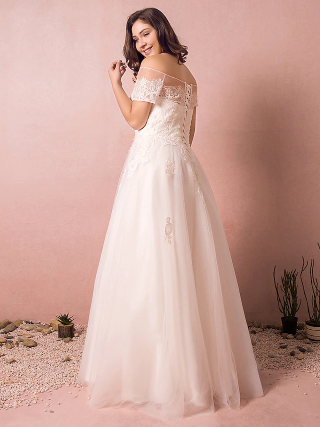 Back view of an A-line wedding dress showing lace and a floor-length skirt.