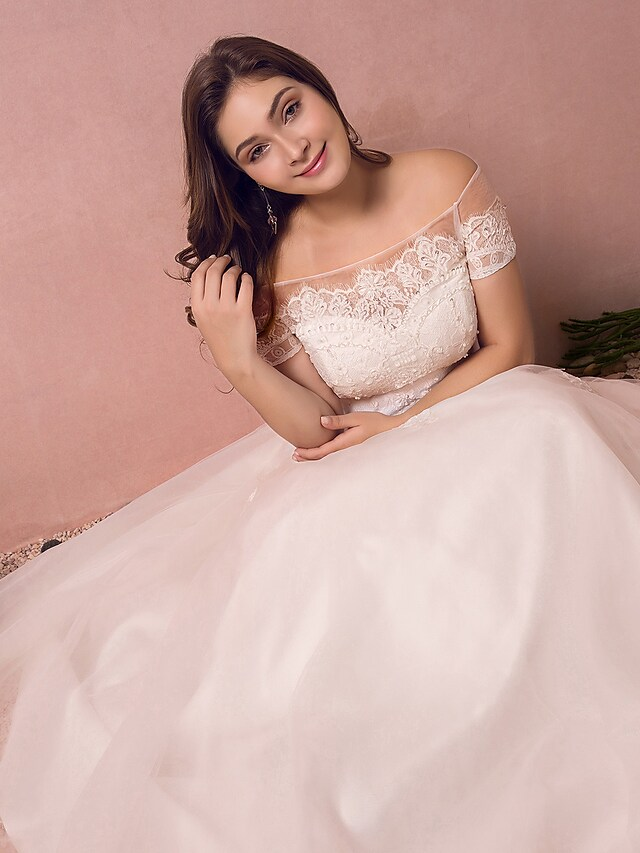 Detail of the short sleeves and off-shoulder neckline on a bridal gown.