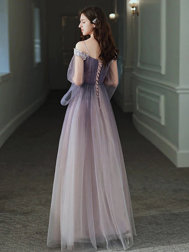 Model posing in a floor-length A-line off-shoulder long sleeve dress.