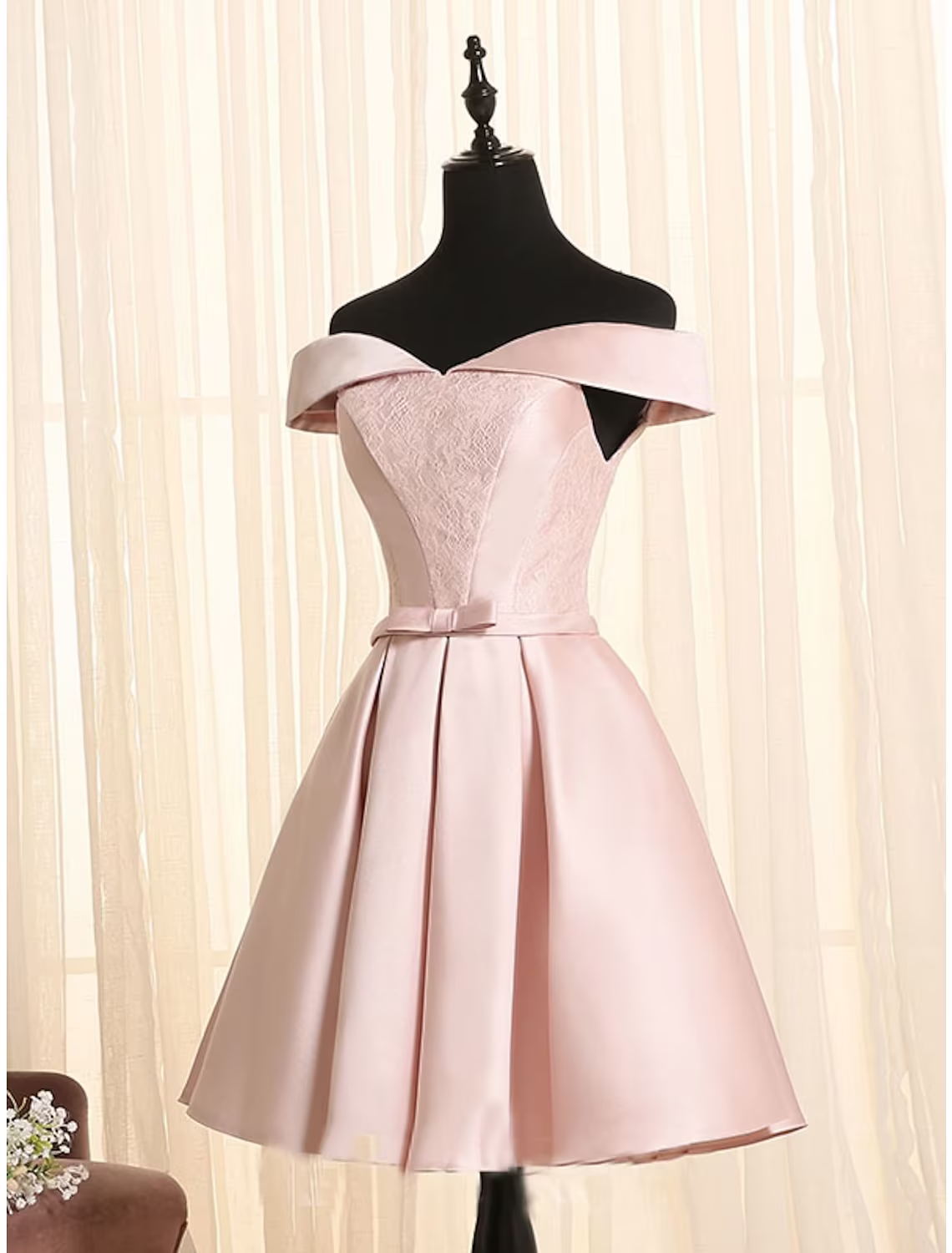 Side view of A-line off-shoulder cocktail dress, showing satin fabric and bow.
