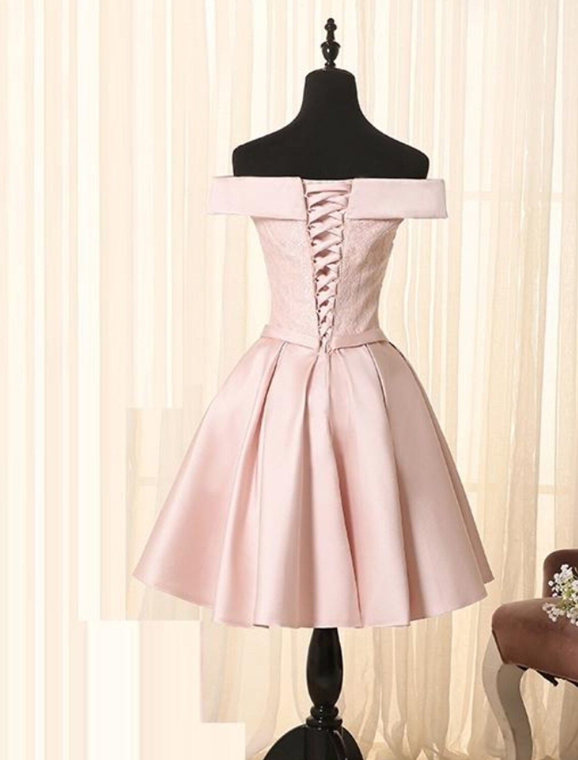 Close-up of lace insert and bow on an elegant satin cocktail dress.