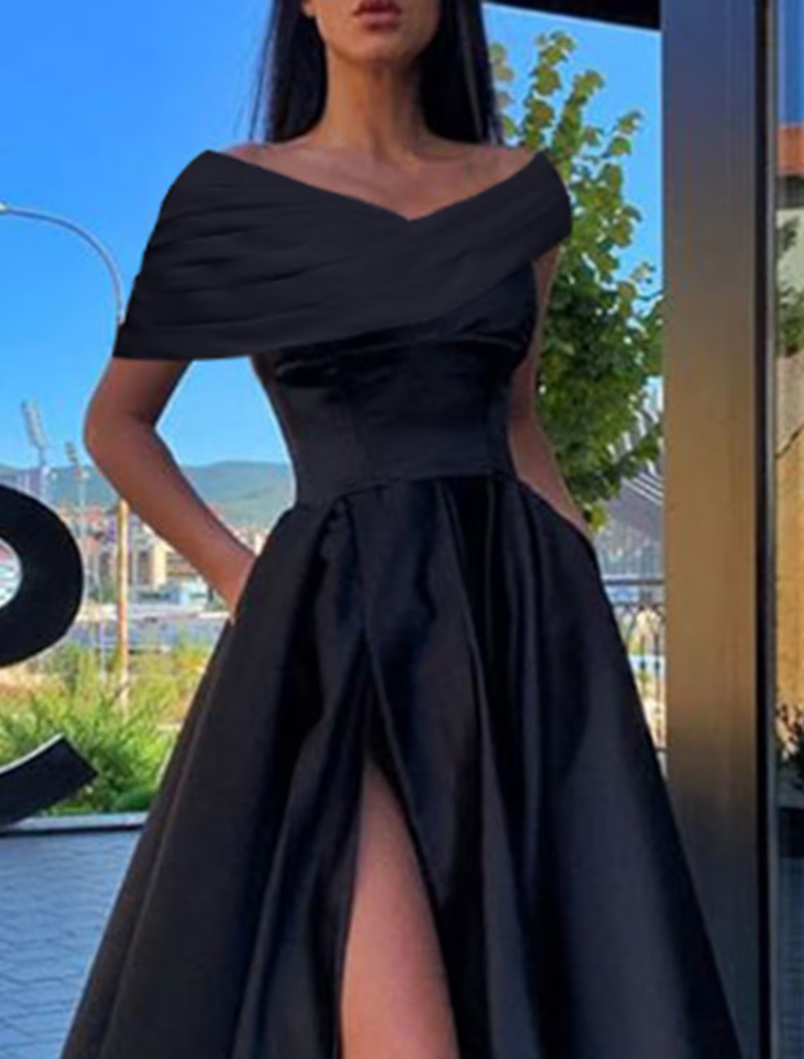Side view of the A-Line off-shoulder black satin prom dress, highlighting the ruched slit.