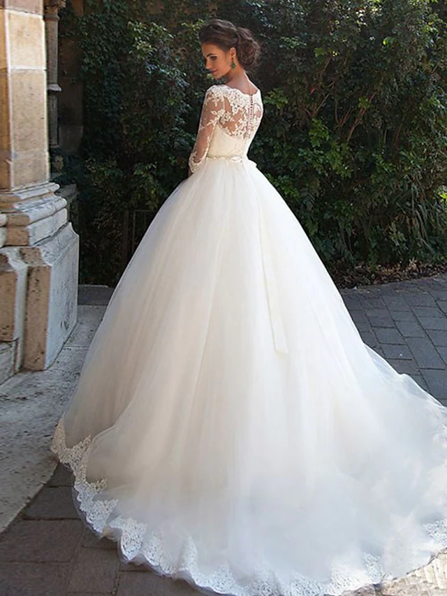Back view of A-Line wedding dress showing court train and illusion lace sleeves.