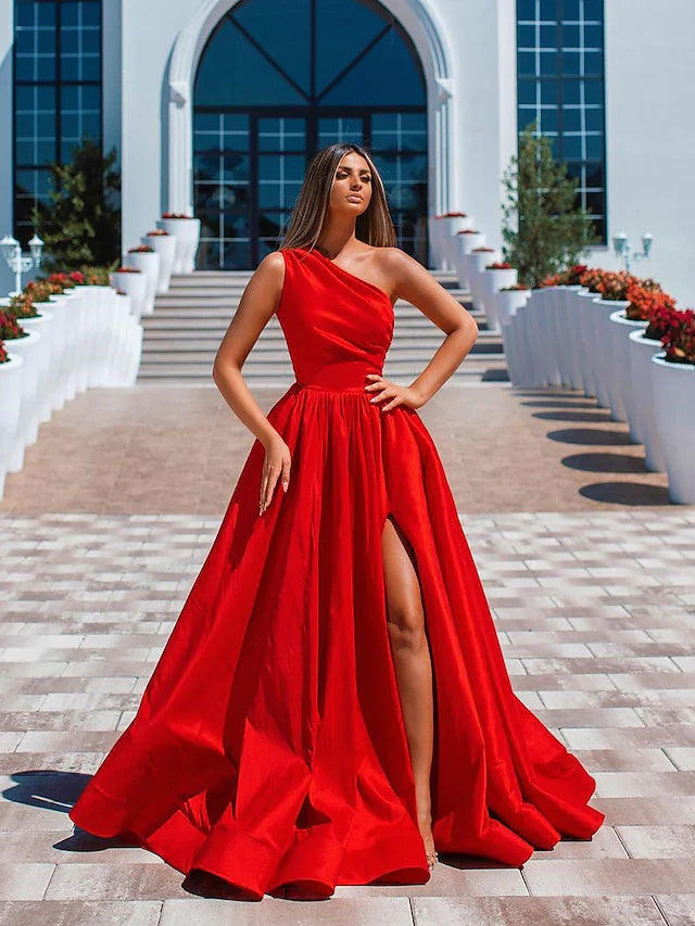 Model wearing an elegant A-line one-shoulder prom dress with a high split and ruched detail.
