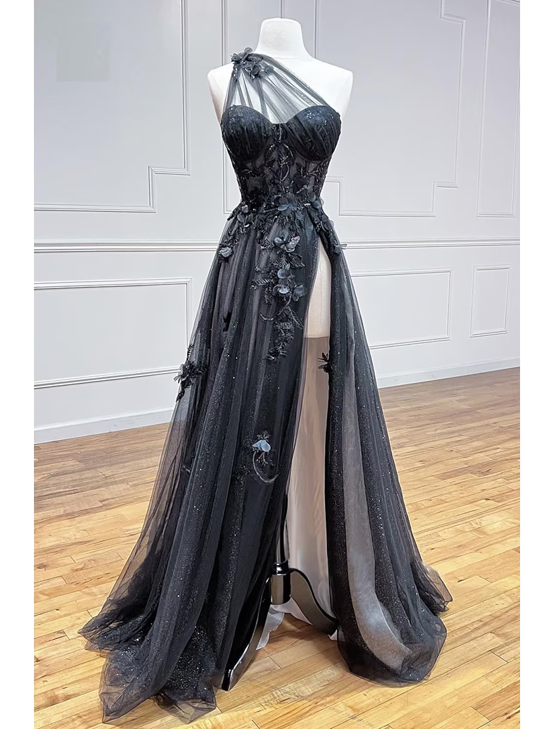 Close-up of the pleated tulle one-shoulder bodice and intricate appliques on the prom dress.