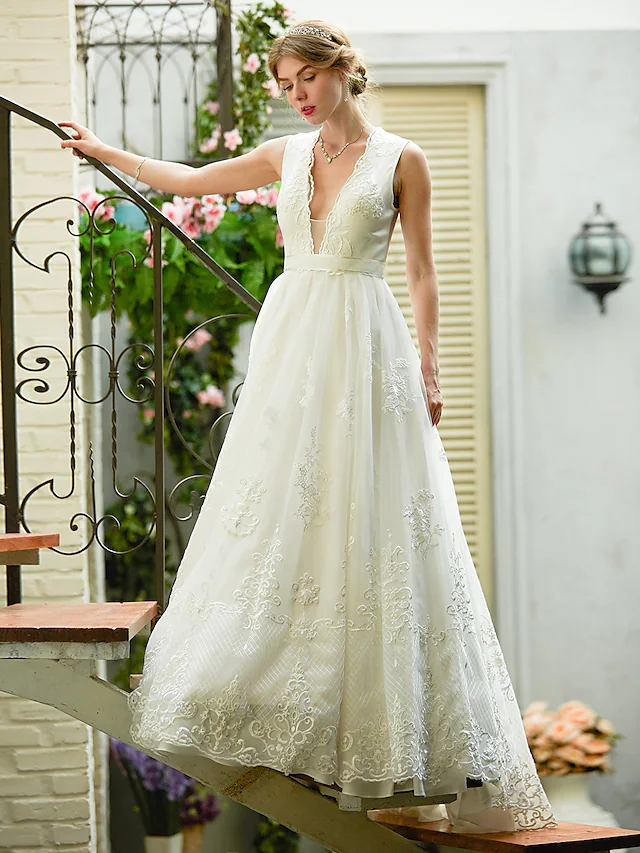 A-line wedding dress with plunging neckline and lace overlay.