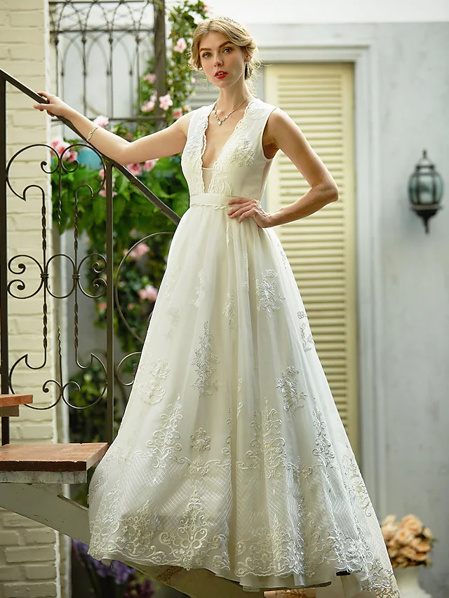 Close-up of plunging neckline with lace appliques on wedding dress.
