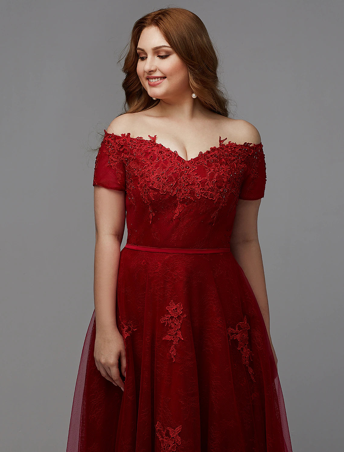 Back view of a plus size A-line dress showing lace-up closure and beading.