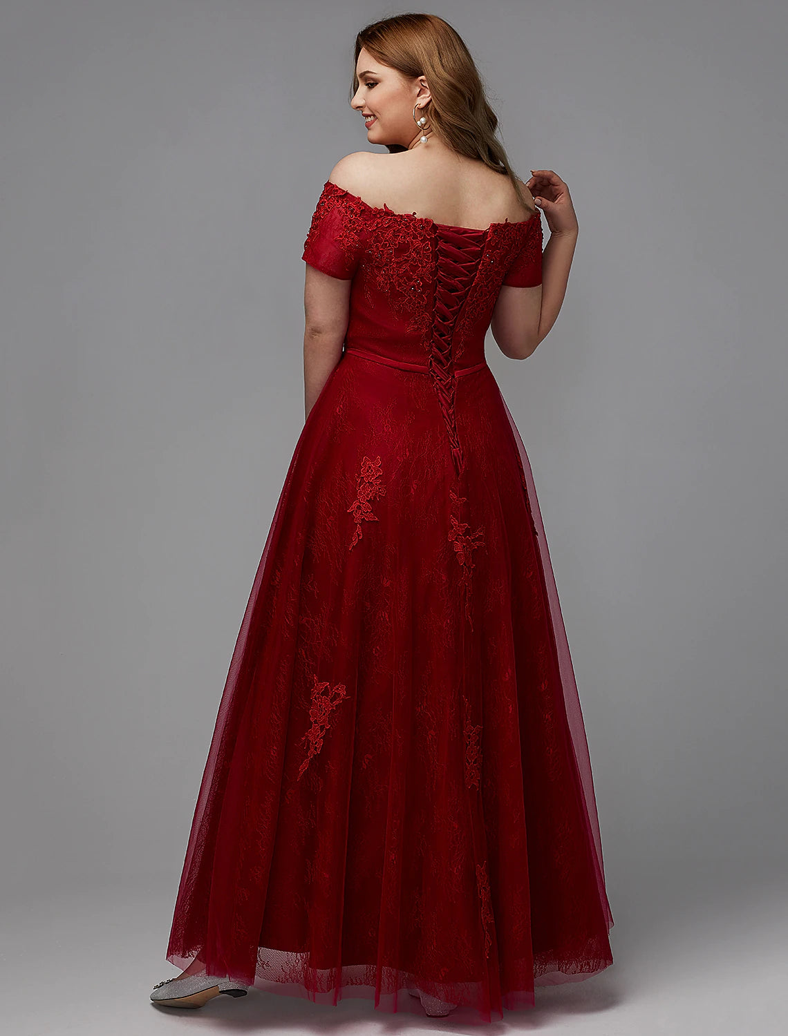 Full length view of a plus size wedding guest dress with short sleeves.