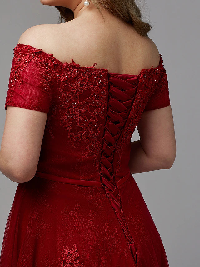 Detail of the off-shoulder neckline and lace appliques on a formal gown.