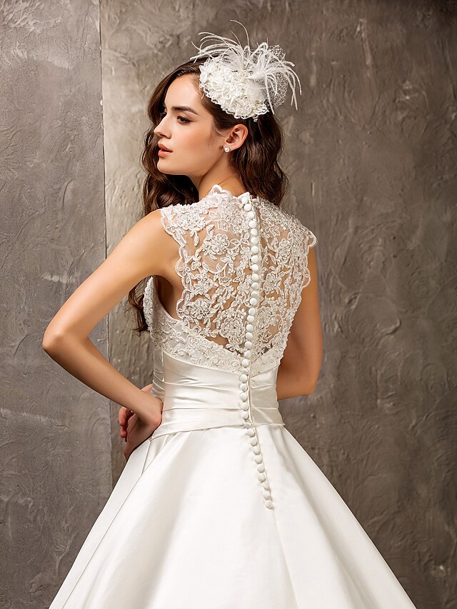 Close-up of the Queen Anne neckline and lace appliques on a wedding dress.