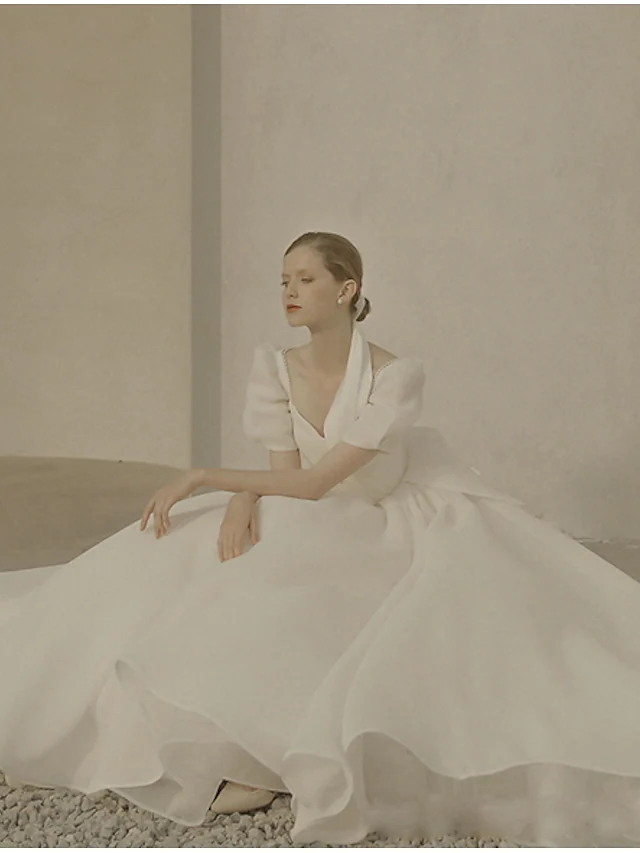 Back view of an A-Line scoop neck short sleeve white organza wedding dress with ruffles.