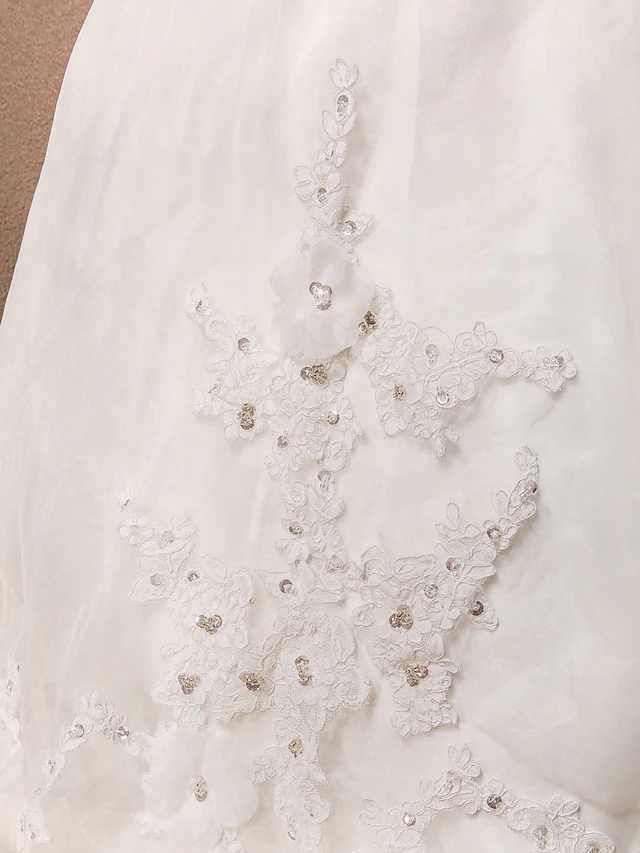 A-line wedding dress with a scoop neck, lace, and organza fabric, suitable for a formal ceremony.