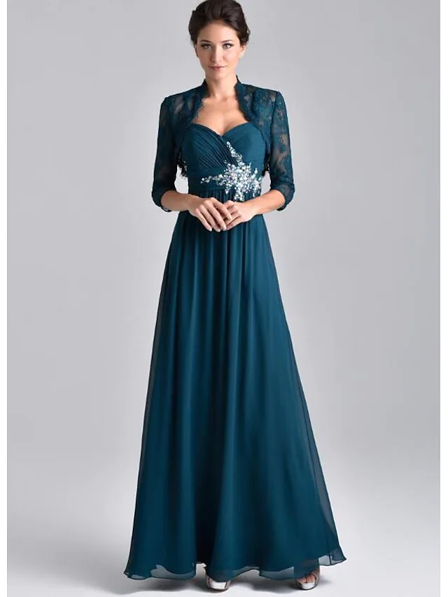Woman wearing an elegant two-piece A-line Mother of the Bride dress with spaghetti straps and a 3/4 sleeve lace jacket.