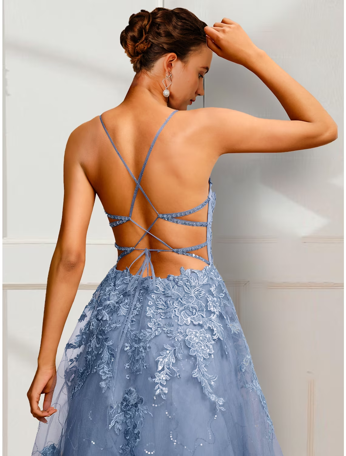 Side view of floor-length A-line prom gown with appliques.