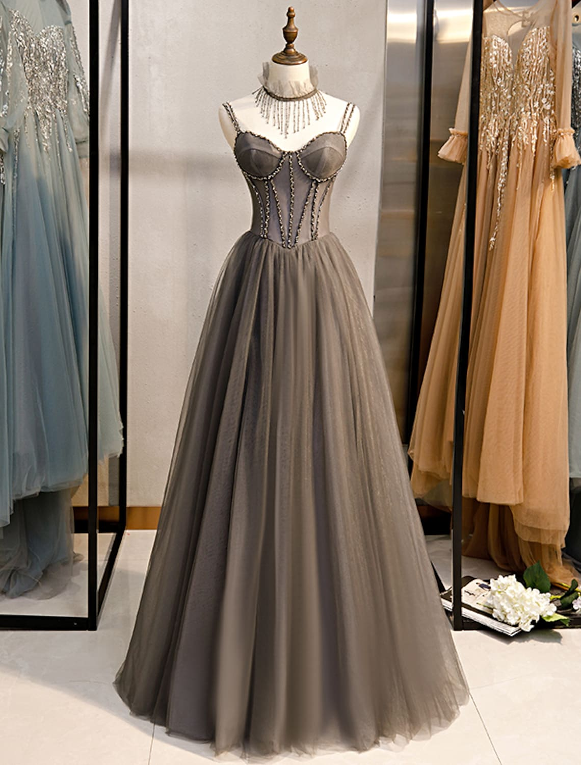 Elegant A-line prom dress with spaghetti straps, pleats, and crystal details.