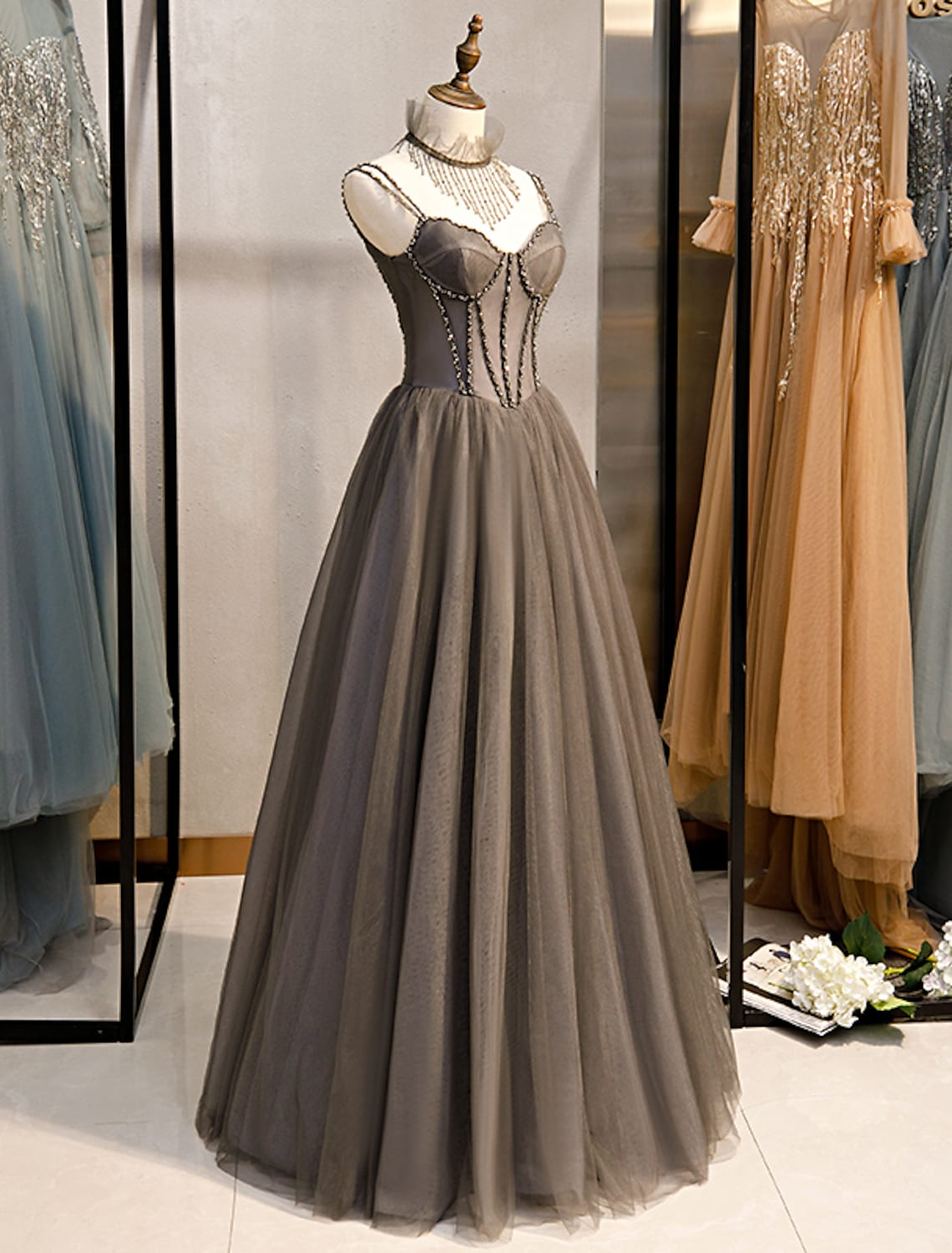 Close-up of the spaghetti strap bodice with crystal embellishments on a tulle prom dress.
