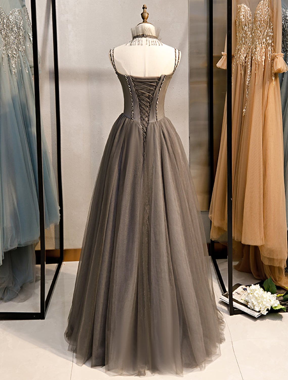 Back view of a floor-length A-line formal dress with delicate straps.