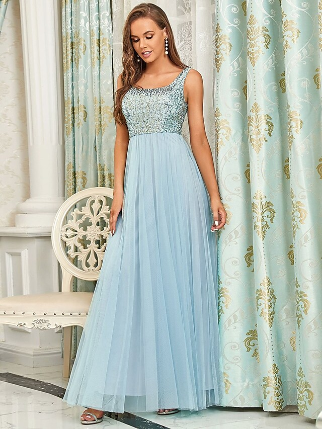 Side profile of an elegant A-line sequined tulle dress with spaghetti straps.