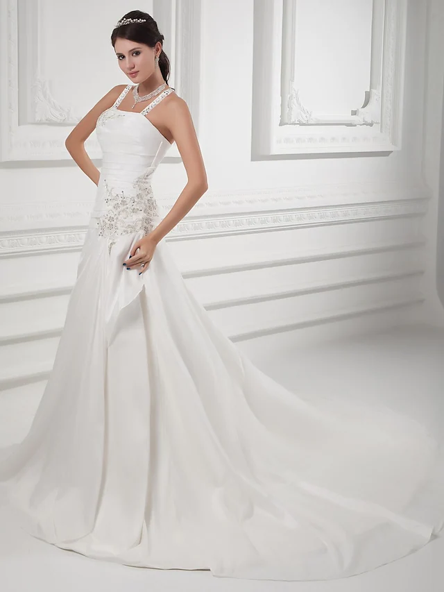 Front view of an elegant A-line wedding dress with a square neckline and spaghetti straps.