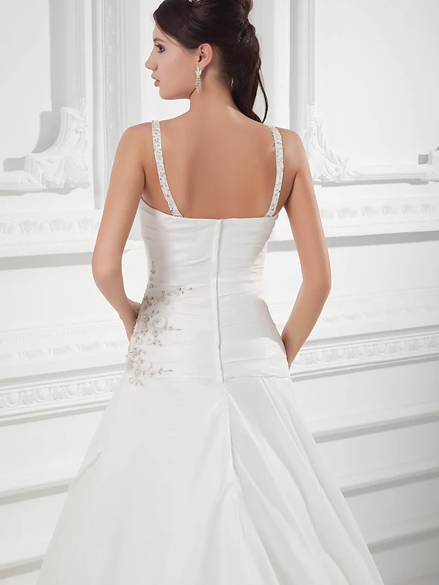 Side view of a satin A-line wedding dress showing ruched bodice and court train.