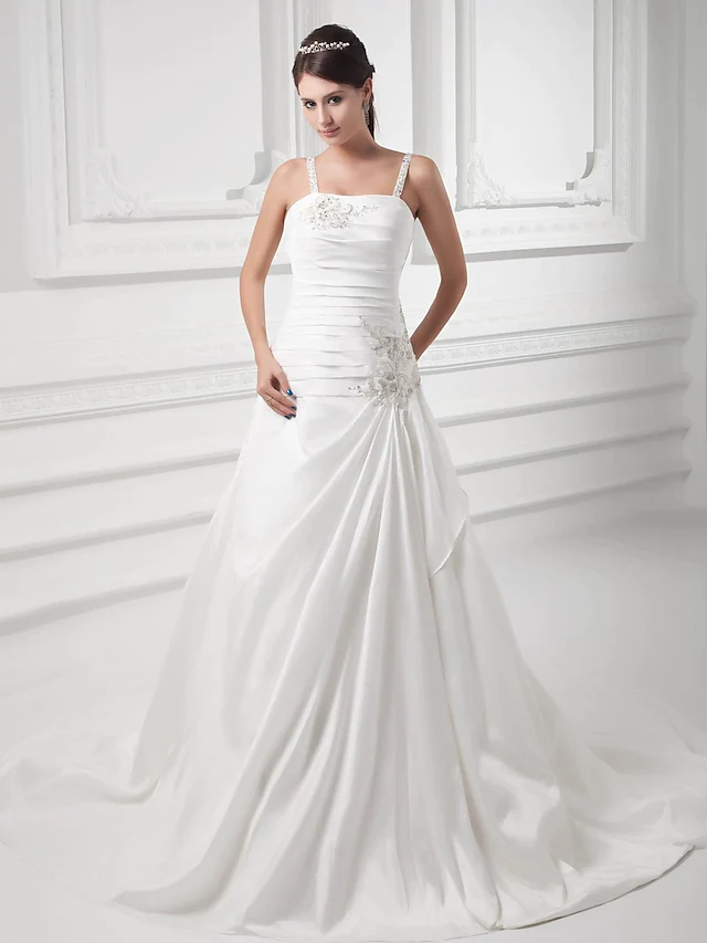 Full length view of a bride wearing an A-line satin wedding dress with a square neckline.