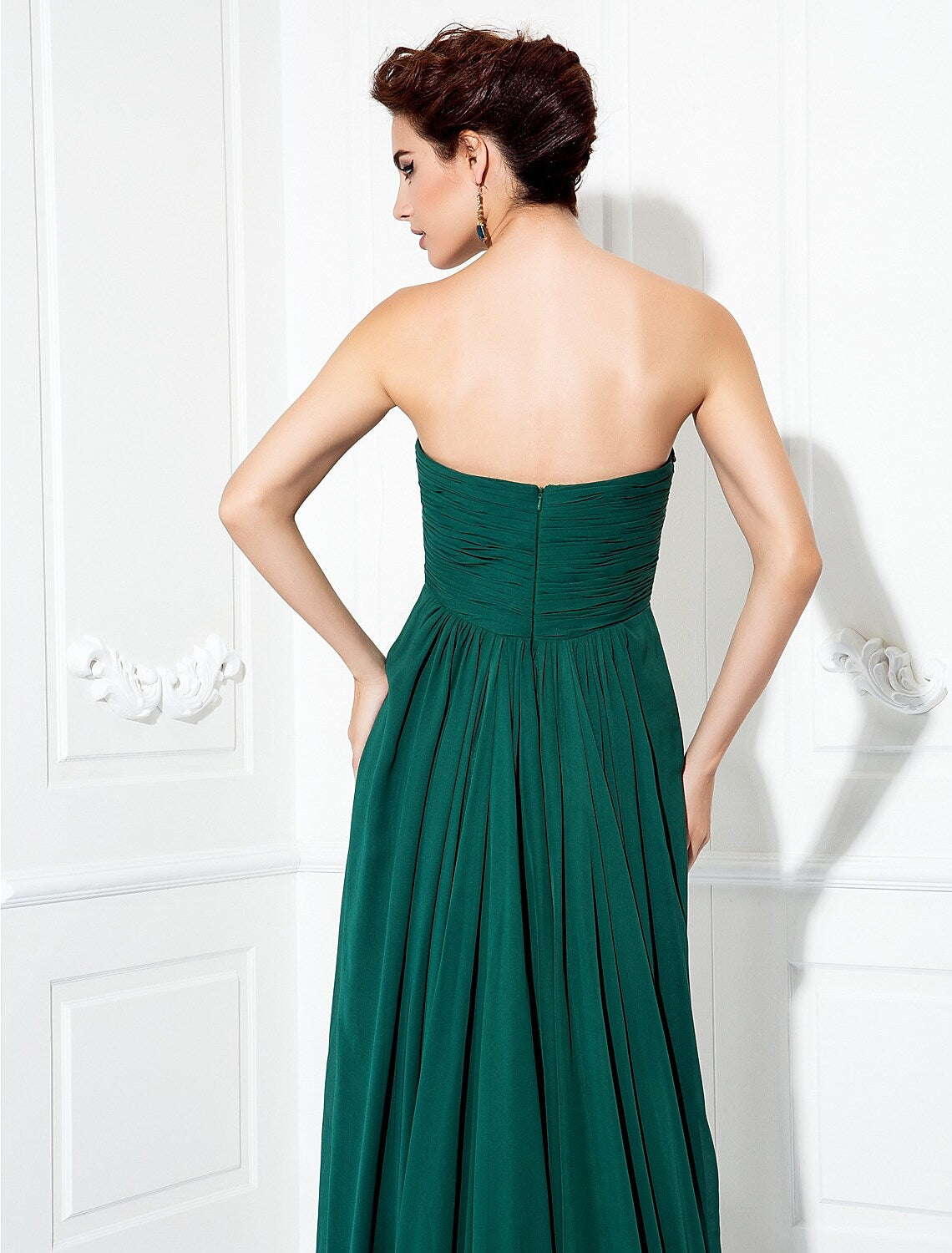 Close-up of the pleated and ruched details on the bodice of the strapless chiffon dress.