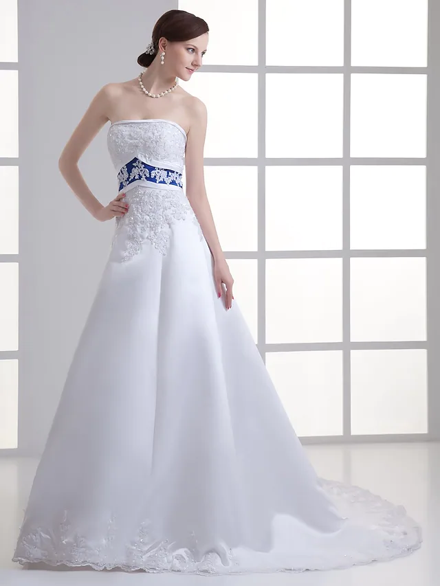 Close-up of lace appliques and beading on a strapless wedding dress.
