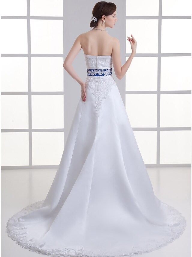 Side view of an A-Line bridal gown with a flowing satin skirt.