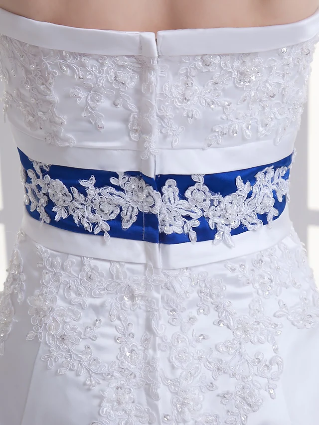 Detail of the beaded sashes and lace on the wedding dress bodice.