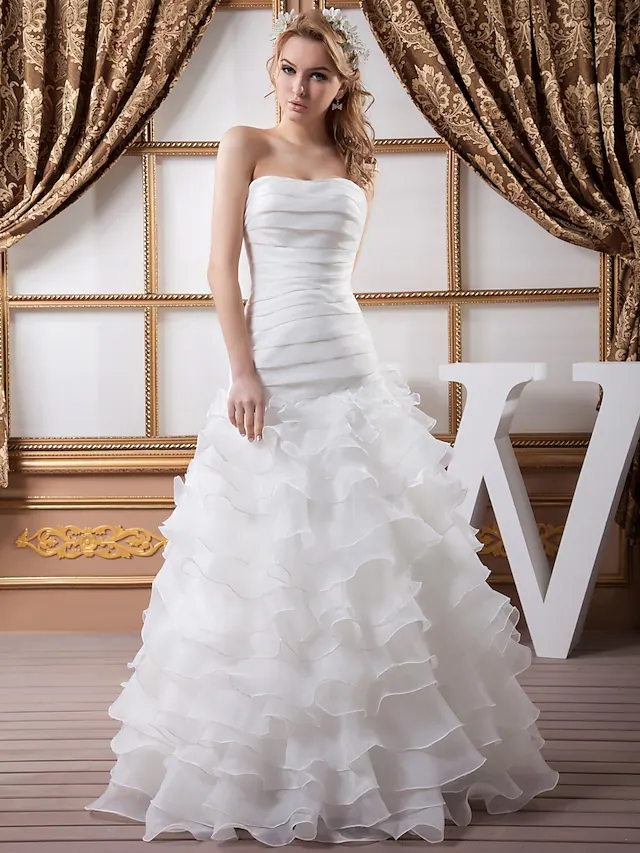 A-Line strapless wedding dress with ruched bodice and cascading ruffles.