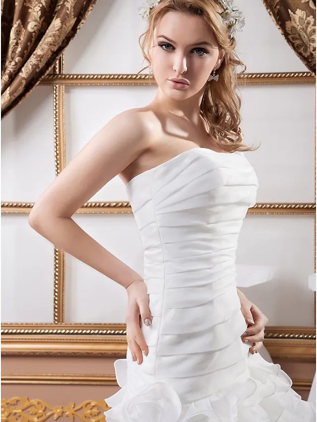 Full view of the strapless A-Line wedding dress with flowing ruffles.