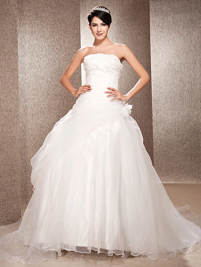 Full view of an elegant strapless A-line organza wedding gown with a court train.