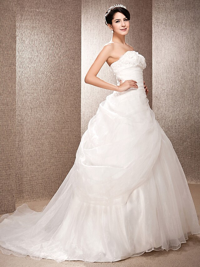 Back view showcasing the flowing court train of the organza wedding gown.